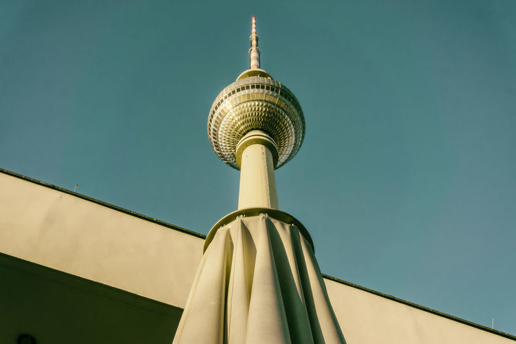 Low angle view of fernsehturm against clear blue sky