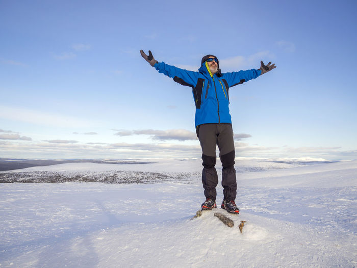 Full length of man standing on snow covered landscape