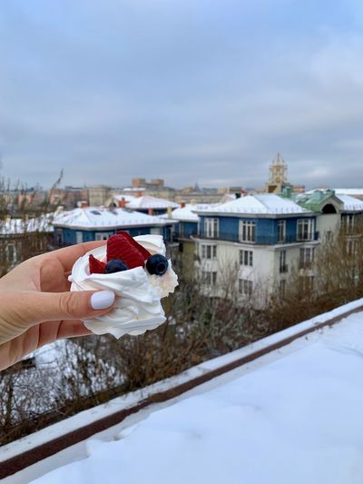 Dessert pavlova in a hand with moscow view