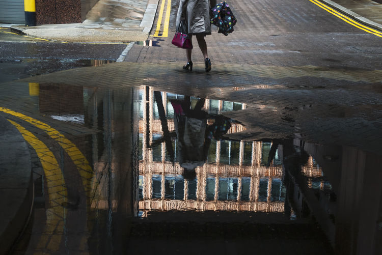 Low section of woman standing on wet street