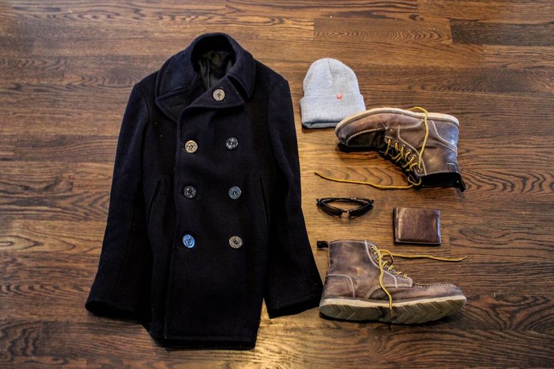 High angle view of jacket and shoes with accessories on hardwood floor