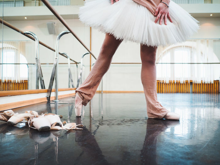 Low section of ballerina dancing on floor