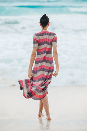 Rear view of woman walking on beach