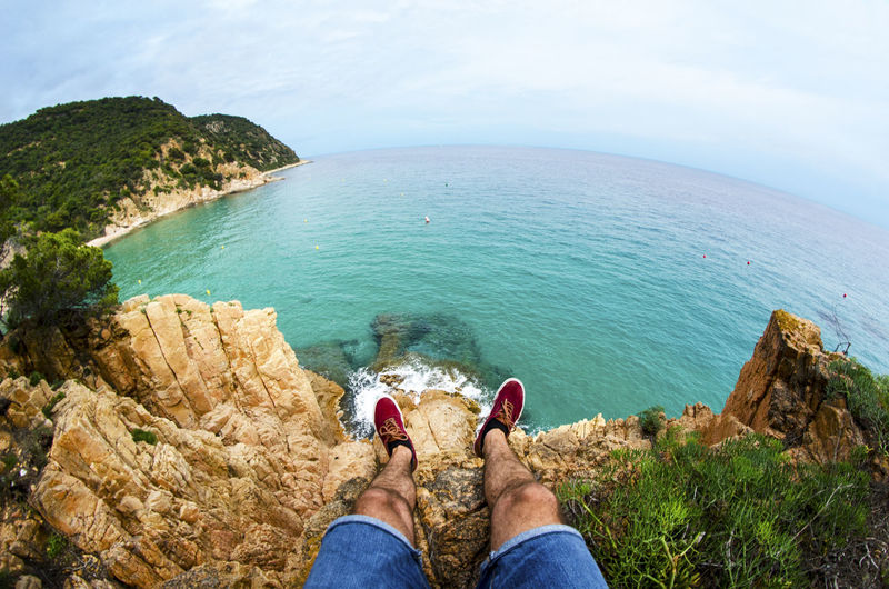 Low section of man on cliff against sea