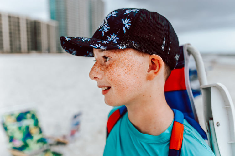 Portrait of boy with freckles looking away wearing a hat