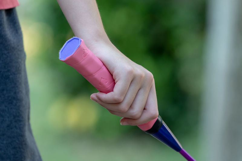 Cropped hand of woman holding badminton racket