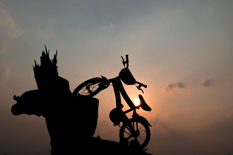 Silhouette of children's bikes with beautiful sunset background.