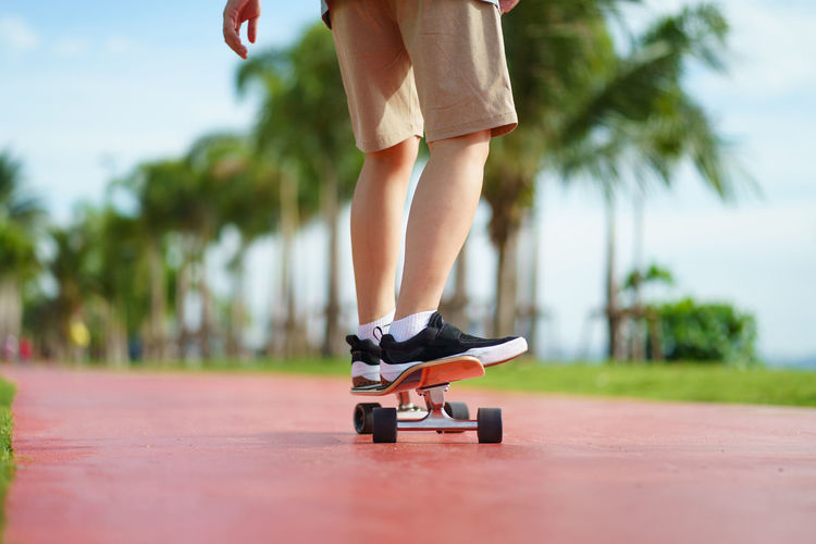 Low section of person skateboarding on land