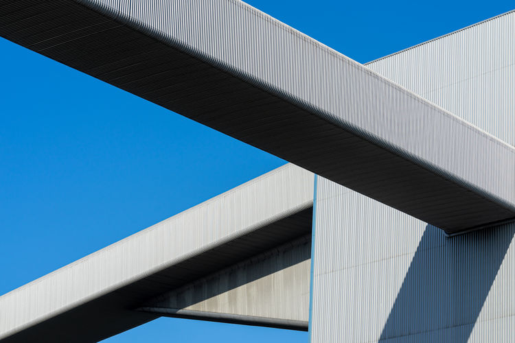 Low angle view of modern factory against clear blue sky