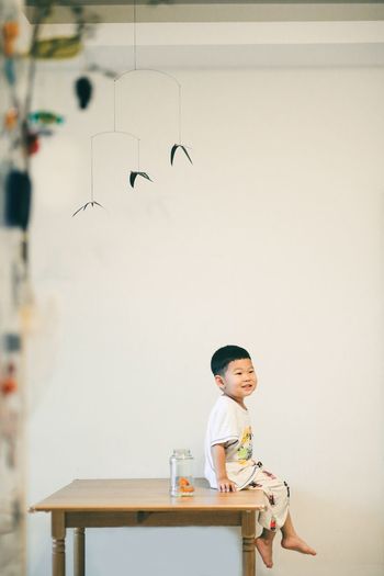 Boy sitting on wall at home