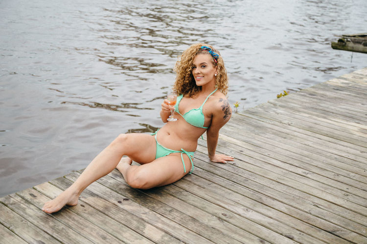 Young woman in bikini sitting on shore