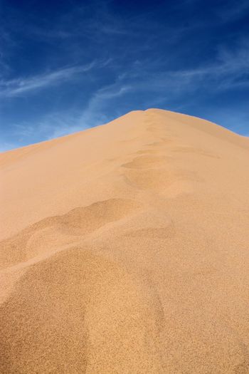 Sand dunes at desert against sky