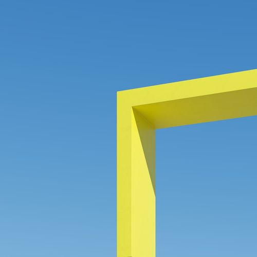 Yellow shape straight building with shadows on sky background. minimal architecture ideas concept. 