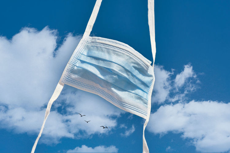 Low angle view of white flags against blue sky