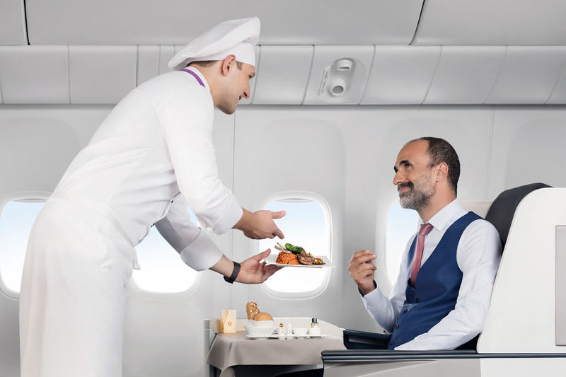 Portrait of a chef serving food to their customer in flight