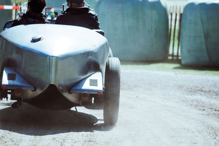 Rear view of men in race car on road