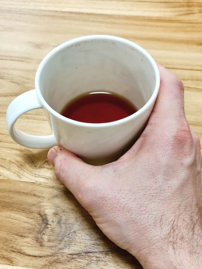 Close-up of hand holding cup of coffee
