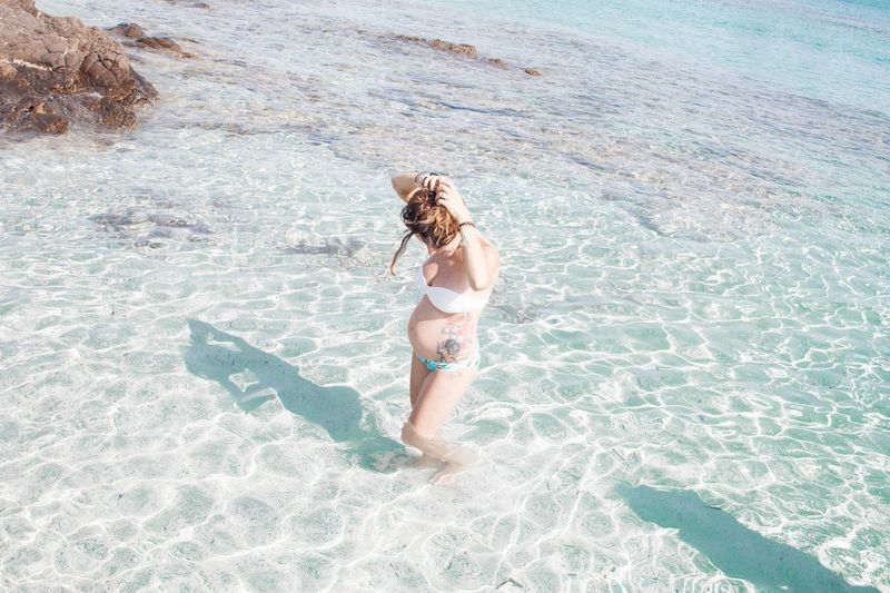Pregnant woman wading in sea