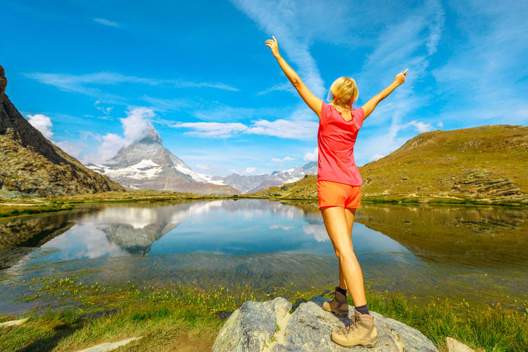 Full length of man standing by lake against mountain