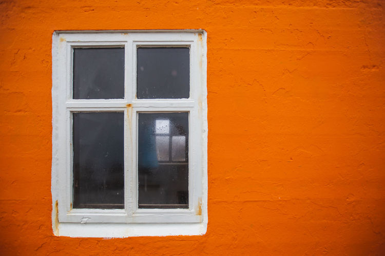 Close-up of window on orange wall