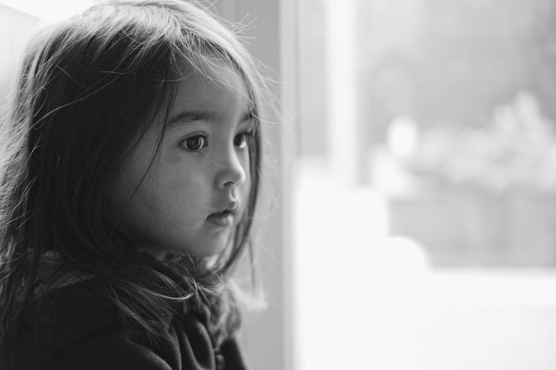 Close-up portrait of a girl looking away at home