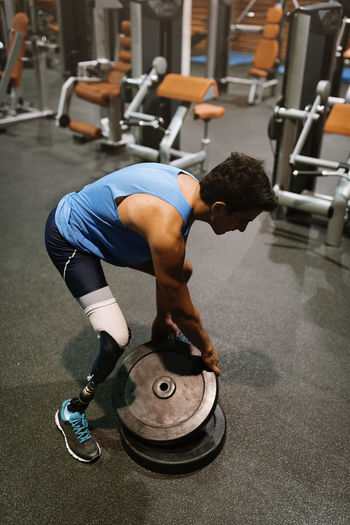 Man with prosthetic leg exercising in gym