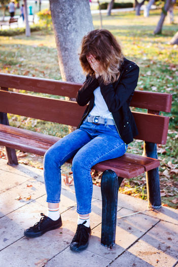 Low section of woman sitting on bench
