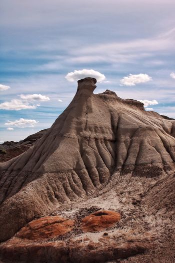 Hoodoo rock formations on landscape against cloudy sky