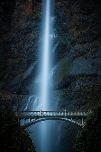 Low angle view of bridge against waterfall at dusk