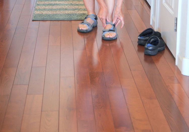 Low section of person wearing shoes at home