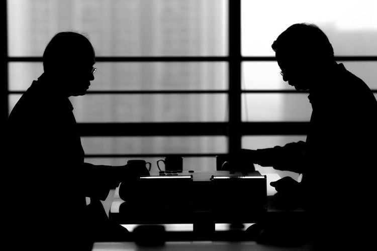 Silhouette men playing go