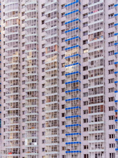 A large number of windows and balconies on building facade. apartment block. residential building.