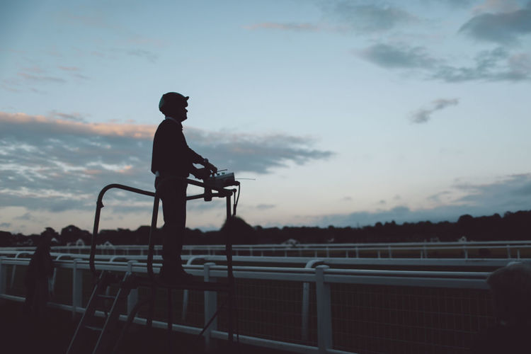 Silhouette man standing on lookout tower at epsom downs racecourse