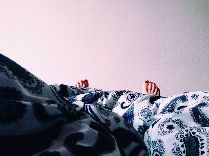 Female feet under soft blanket 