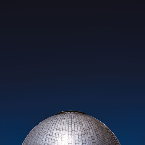 Low angle view of building dome against clear blue sky