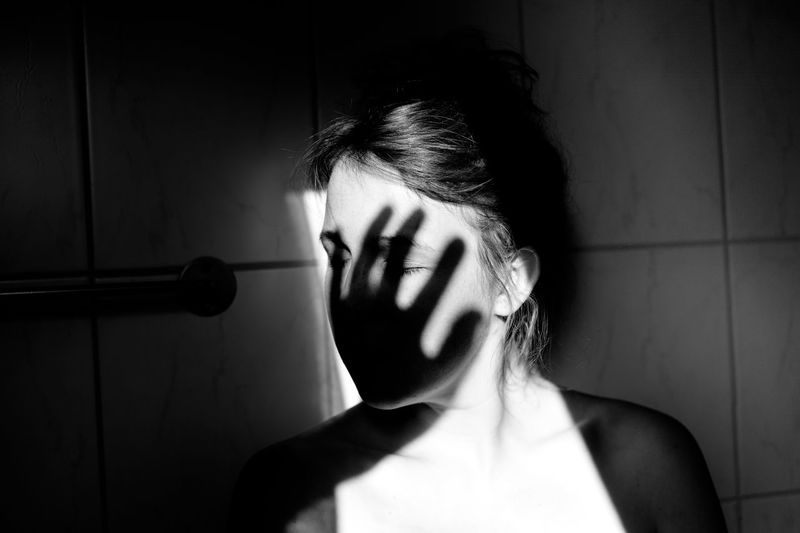 Portrait of woman with hand shaped shadow over face