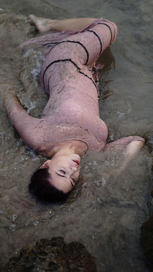 High angle view of woman lying down in mud