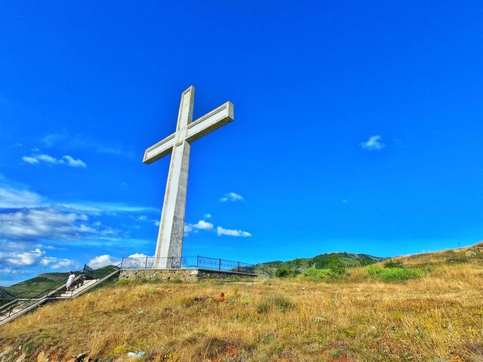 Low angle view of cross on top of the hill against sky