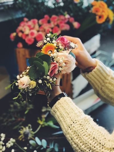 Cropped hands holding bouquet in flower shop