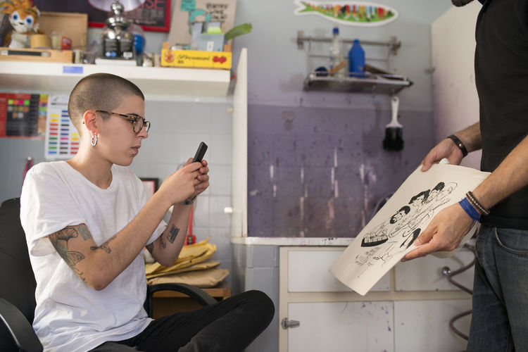 Female designer taking photo of new print