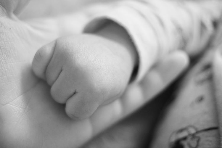 Cropped image of mother and child holding hands