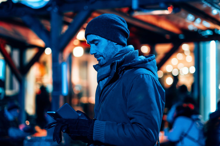 Man outdoor in the city using a mobile phone - stylish freelancer in the winter season