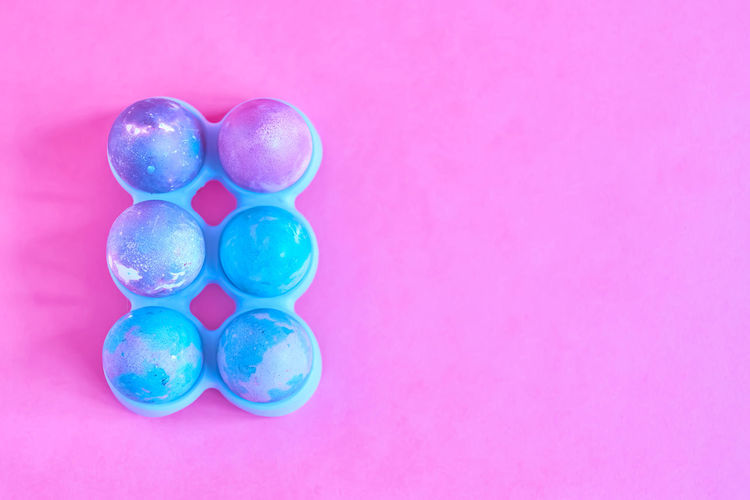 Directly above shot of multi colored candies against pink background