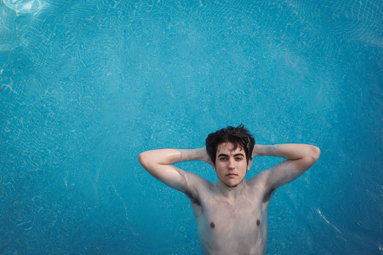 Portrait of a young man swimming in pool