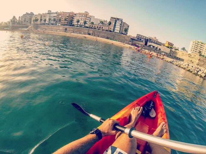 Low angle view of person on sea against city