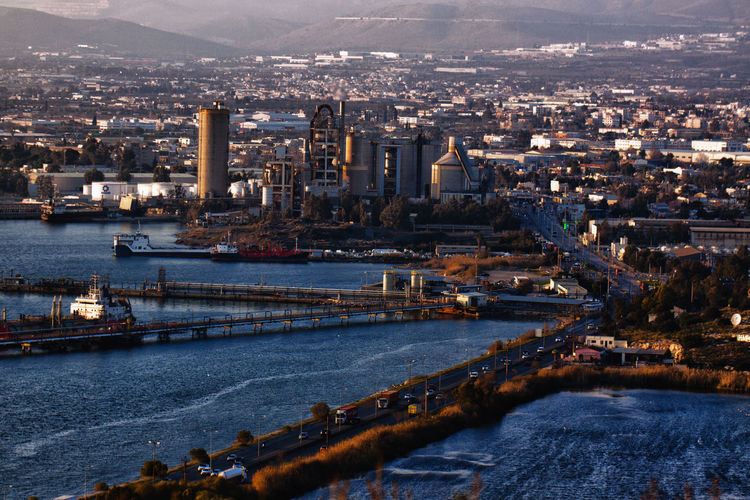 High angle view of river and buildings in city and industrial plant
