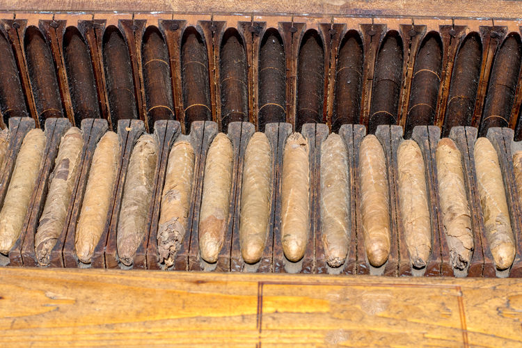 Vintage cigars rest in a wooden cigar case