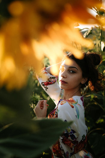 Portrait of young woman with leaves outdoors