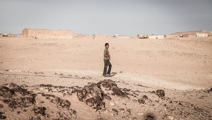 WOMAN STANDING IN DESERT