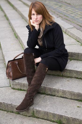 Portrait of woman with purse sitting on steps
